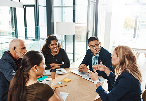 colleagues discuss real estate around a table